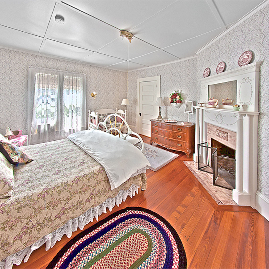 tourmaline room bed, fireplace, and hardwood floors